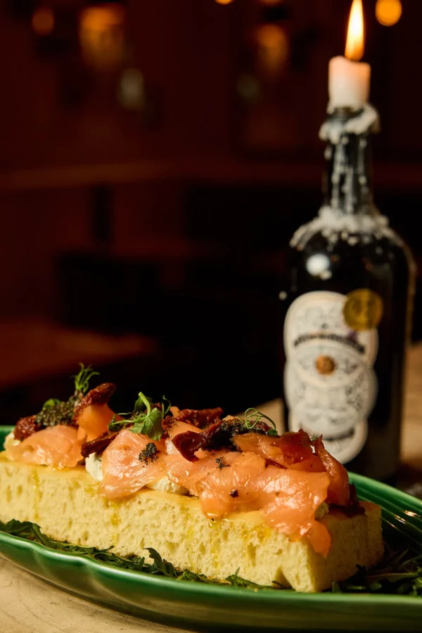 Pinsa saumon restaurant in casa levallois perret Pinsa au saumon avec Ricotta, pesto, tomates séchées et roquette servie au restaurant italien In Casa à Levallois-Perret