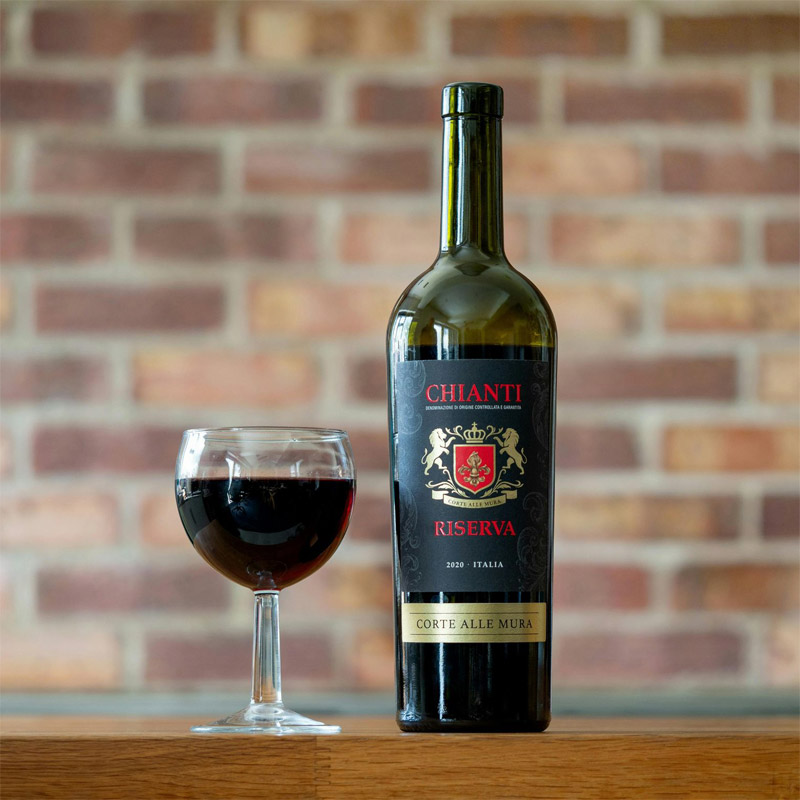 Vin Chianti – sélection italienne – In Casa Levallois Bouteille de Chianti et verre de vin rouge servis dans le restaurant italien In Casa à Levallois-Perret