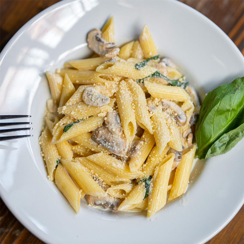 Penne aux champignons et parmesan – In Casa Levallois Assiette de penne aux champignons, parmesan et basilic, servie dans le restaurant In Casa à Levallois-Perret