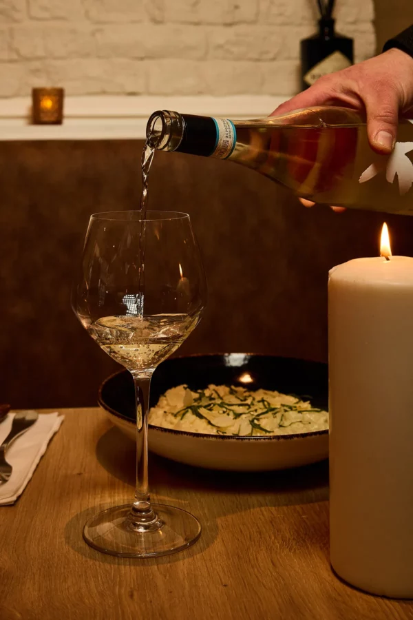 Service de vin blanc dans un verre à pied au restaurant italien In Casa à Levallois-Perret